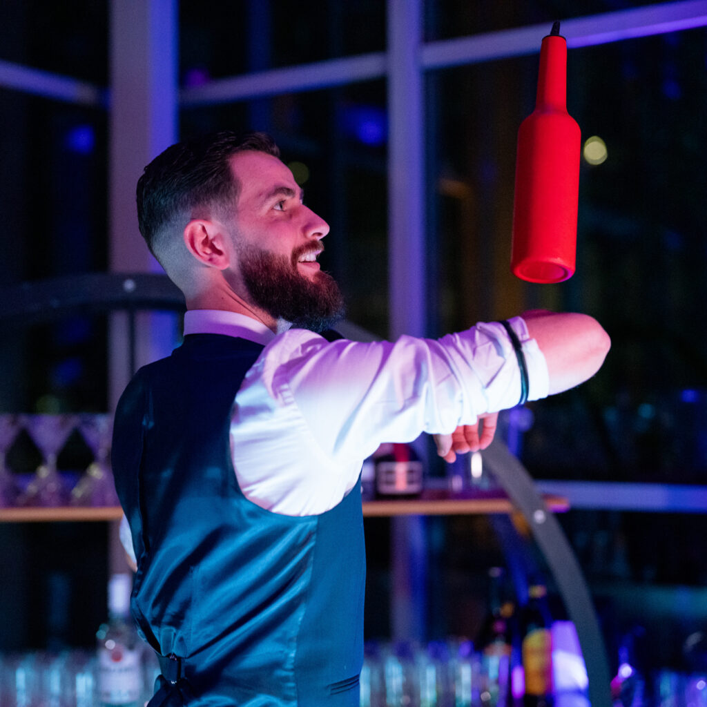 Barman qui jongle avec des bouteilles